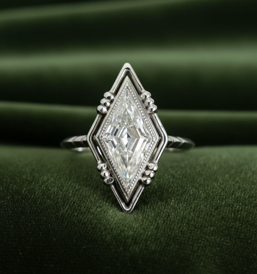 Kite-shaped diamond ring on dark olive green velvet