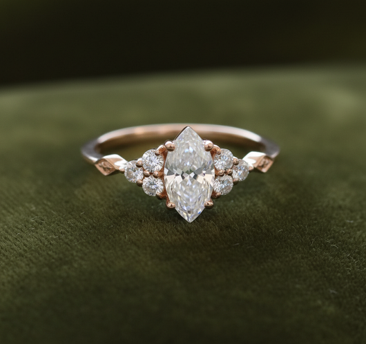 Rose gold marquise moissanite ring on dark olive green velvet