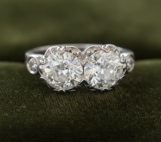 Two-stone diamond ring on dark olive green velvet